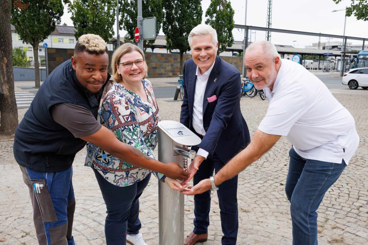 Netzmonteur Sergio Ruf, Geschäftsführerin Martina Braun, OB Matthias Steffan und Olaf Türke beim Trinkwasserbrunnen